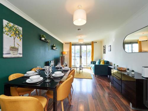 a dining room with a black table and chairs at Cosy Emerald Suite - Two Story Duplex Apartment - Balcony - Contractors - Family - City Centre - Broadway Plaza - Five Ways - Sleeps 6 in Birmingham