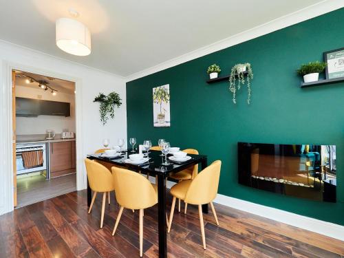 a dining room with a black table and yellow chairs at Cosy Emerald Suite - Two Story Duplex Apartment - Balcony - Contractors - Family - City Centre - Broadway Plaza - Five Ways - Sleeps 6 in Birmingham