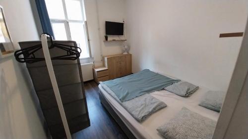 um pequeno quarto com 2 camas e uma televisão em Aradi Rooms with Private bathroom em Budapeste