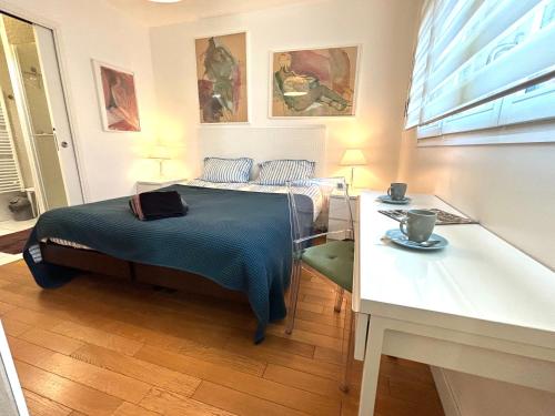 une chambre avec un lit, un bureau et une table dans l'établissement L'appartement Terrasse de Grenelle, à Paris