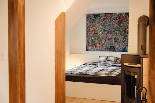 Cama pequeña en habitación con una pintura en la pared en Idylische Ferienunterkunft, en Heitersheim