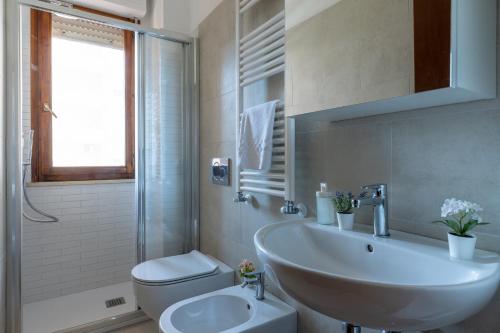 a white bathroom with a sink and a toilet at Cisanello Lovely Apartment in Pisa in Pisa