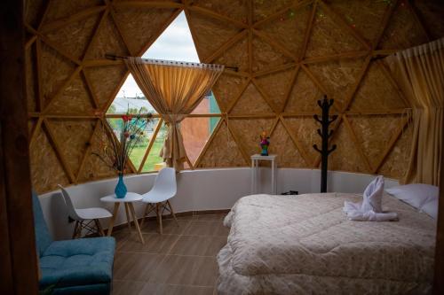 Magia Verde Glamping في Tinjacá: غرفة نوم مع سرير كبير في يورت