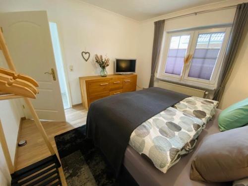 a bedroom with a bed and a tv on a dresser at Ferienwohnung Wellenkamp in Itzehoe