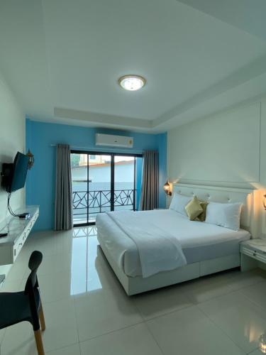 a bedroom with a large bed and a balcony at Love you Hotel in Phitsanulok