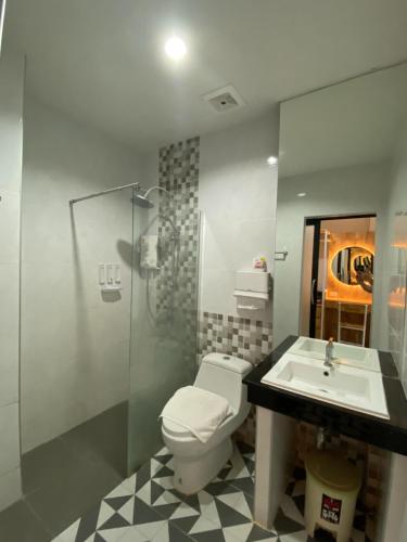 uma casa de banho com um WC, um lavatório e um chuveiro em Love you Hotel em Phitsanulok