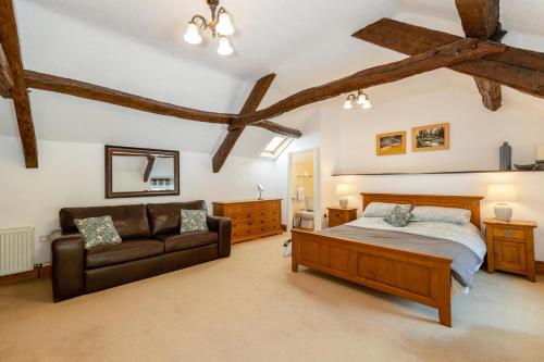 a bedroom with a bed and a couch at Country House with Heated Swimming Pool & Gardens in Rhiw