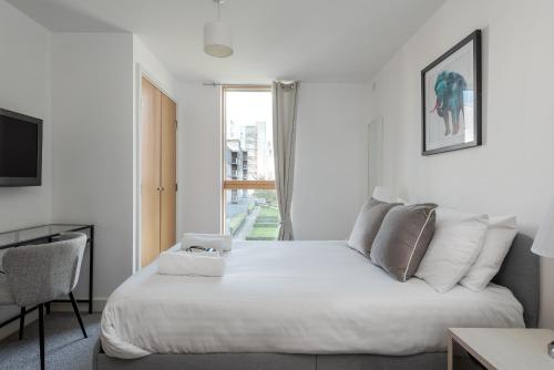 a bedroom with a white bed and a window at City Stay Apartments - Vizion in Milton Keynes
