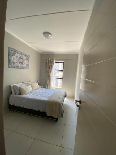 a bedroom with a bed and a window at Evergreen On Lever in Midrand