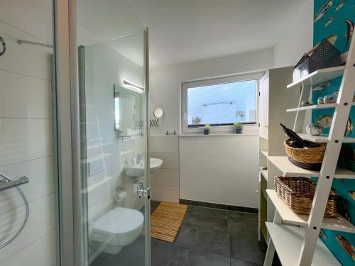 ein Bad mit einer Dusche, einem WC und einem Waschbecken in der Unterkunft Schwimmendes Haus am Pier in Olpenitz