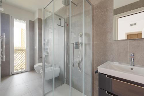 La salle de bains est pourvue d'une douche, d'un lavabo et de toilettes. dans l'établissement Amazing & Central Milan Apt - City Life District!, à Milan