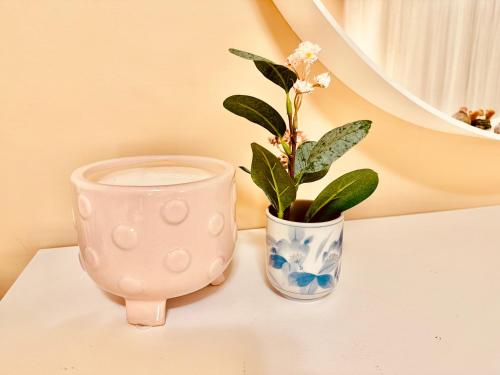 a pink vase and a vase with a plant on a table at Scorpion Hiuse Langley -ROOM A in Langley