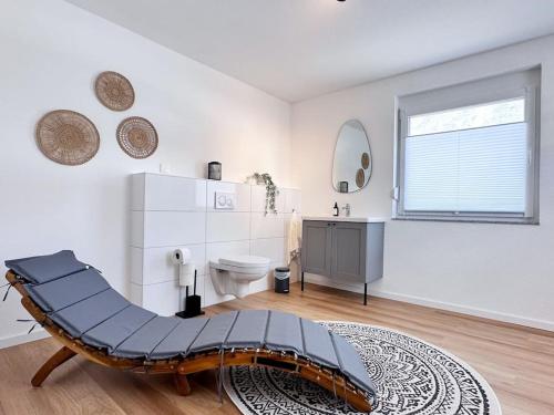 a white bathroom with a bench in the middle of a room at Appartio: Geräumige, moderne Ferienwohnung für Gruppen/Familien in Stuttgart