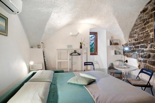 a bedroom with a bed and a stone wall at Grazioso open space in Sanremo