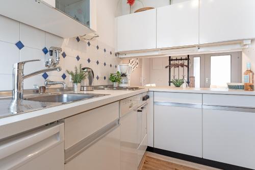 a kitchen with white cabinets and a sink at Kammerweg 5, Nordlicht in Scharbeutz