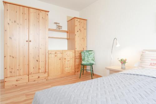 um quarto com uma cama, uma cadeira e um armário em Kammerweg 5, Nordlicht em Scharbeutz