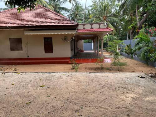 a small house with a red roof at Villa in Kalviyankadu in Irupalai