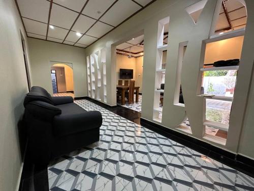 a living room with a black couch in a room at Villa in Kalviyankadu in Irupalai