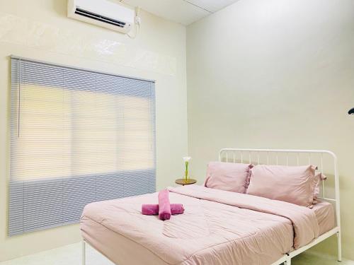 a bedroom with a bed with a pink stuffed animal on it at SOFEA HOMESTAY in Pantai Cenang