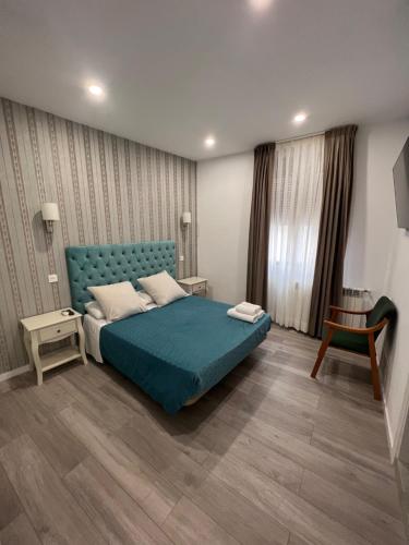 a bedroom with a blue bed and a table at Hostal Galaico in Madrid