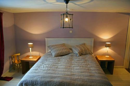 een slaapkamer met een bed met 2 tafels en 2 lampen bij Tony in Vielsalm