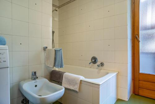 ein Badezimmer mit einem Waschbecken und einer Badewanne in der Unterkunft Casa Magda in Tesero