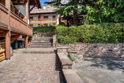 a stone walkway in front of a building with stairs at Casa Magda in Tesero