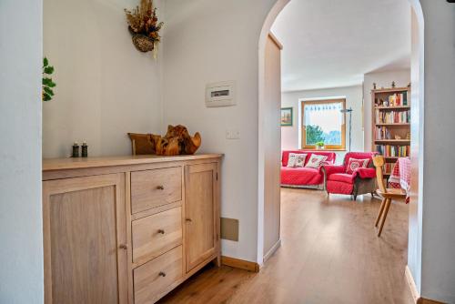 a living room with a wooden dresser and a living room with a couch at Casa Magda in Tesero
