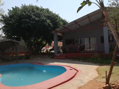 a swimming pool in front of a house at ANSTA SELF CATERING Home in Outjo