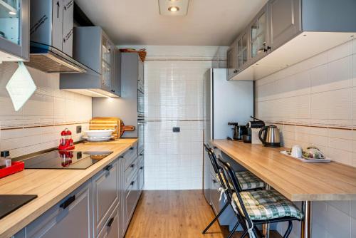 a kitchen with white cabinets and wooden counter tops at Casa Magda in Tesero