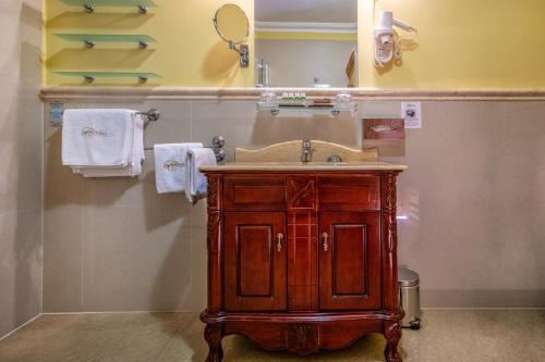 a bathroom with a sink and a mirror and towels at La Contessa Castle Hotel in Szilvásvárad