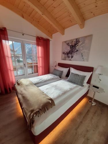 1 dormitorio con 1 cama grande y cortinas rojas en Hochalmbahnen Chalets Rauris 1-01 Maislaufeldweg 1a, en Rauris