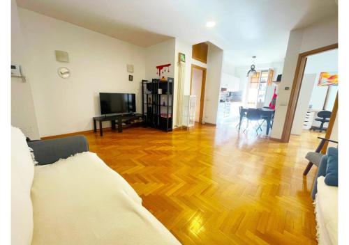 Cozy Casetta - Bright and near Metro C في روما: غرفة معيشة مع أريكة وأرضية خشبية
