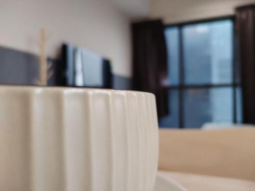 a white coffee cup sitting on top of a table at Icon Residenz Icon City, Petaling Jaya by De Harlequins Guesthouse in Petaling Jaya