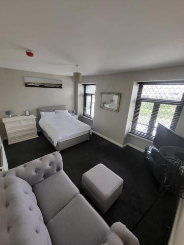 a large bedroom with a bed and a couch at The Dublin Packet Apartment in Holyhead