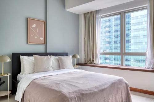 - une chambre avec un grand lit et une grande fenêtre dans l'établissement The Radiant Retreat 2BR apartment in Singapore, à Singapour