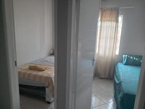 a small bedroom with a bed and a window at Las Palmas Day & Night Guest House in Pretoria