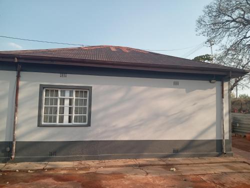 un garage bianco con una finestra di Las Palmas Day & Night Guest House a Pretoria