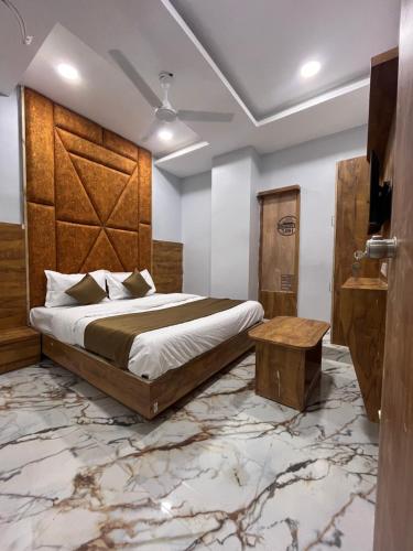 een slaapkamer met een groot bed en een houten hoofdeinde bij HOTEL KRISHNA in Ahmedabad