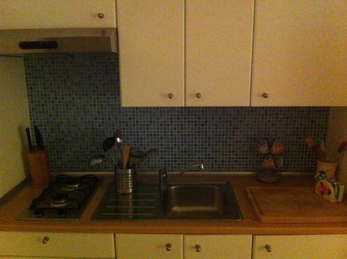 a kitchen with a sink and a stove and cabinets at Casa Marea in Marzamemi