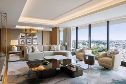 a living room with a couch and chairs and windows at The Westin Yokohama in Yokohama