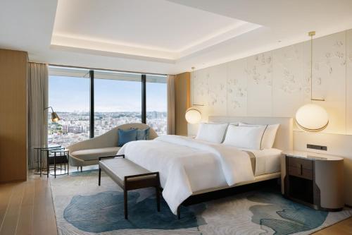横浜市にあるウェスティンホテル横浜のベッドルーム(大きな白いベッド1台、ソファ付)
