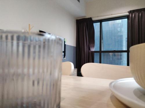 a glass sitting on top of a table with a window at Icon Residenz Icon City, Petaling Jaya by De Harlequins Guesthouse in Petaling Jaya