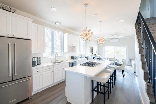 a kitchen with white cabinets and a kitchen island with bar stools at 4048 Stylish condo in Hillcrest Mission Hills in San Diego