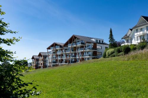 a building on top of a grassy hill at Weitblick Winterberg in Winterberg