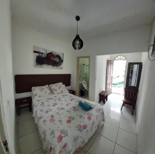 um quarto com uma cama com colcha floral em Pousada Casa Verde em Guarapari