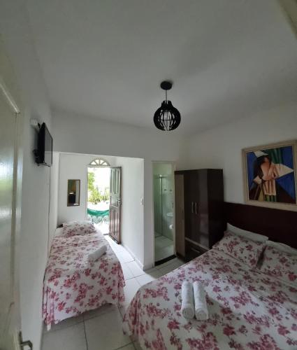 una camera con due letti e uno specchio di Pousada Casa Verde a Guarapari