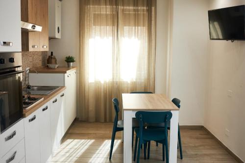 桑格羅堡的住宿－Appartamento Felicia，厨房配有桌椅和窗户。