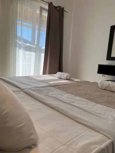 two beds in a room with a window at Jessica's Studios & Apartments in Kavos