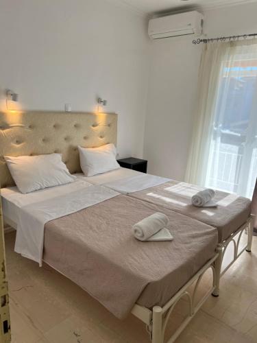 a bedroom with a large bed with two towels on it at Jessica's Studios & Apartments in Kavos